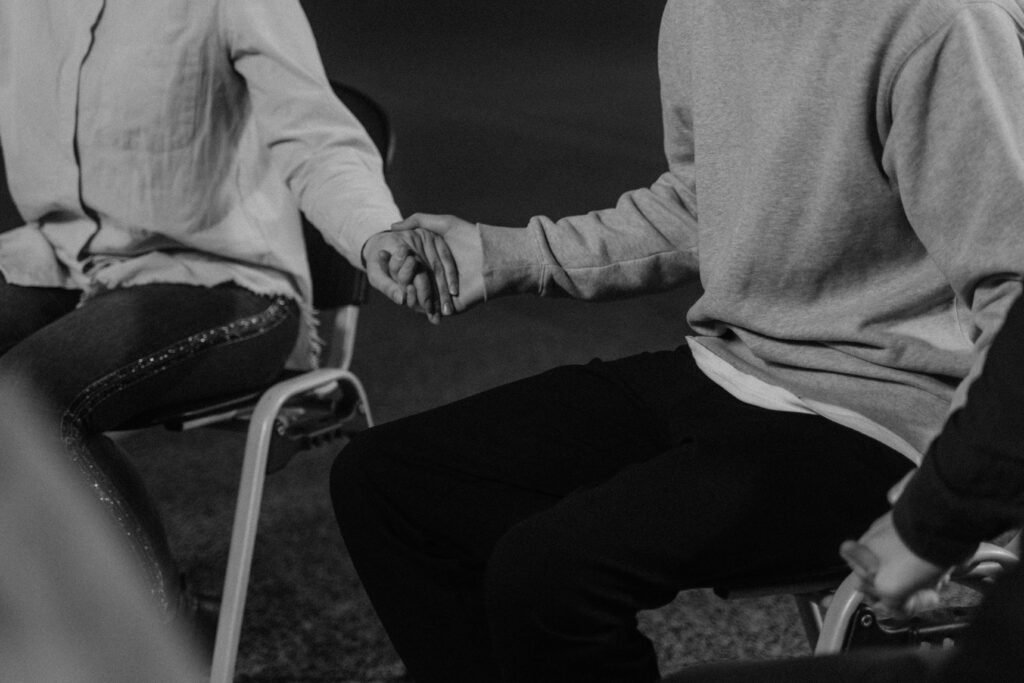 Woman in White Long Sleeve Shirt and Black Pants Sitting on Chair